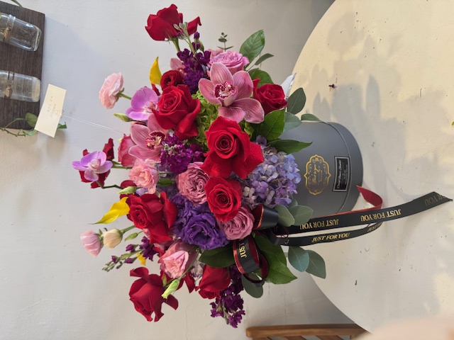 Arrangement with red, pink, and purple roses