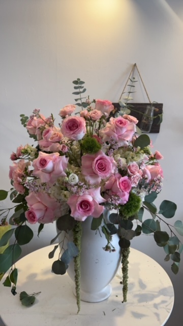 Pink roses, baby breath, and green leaves