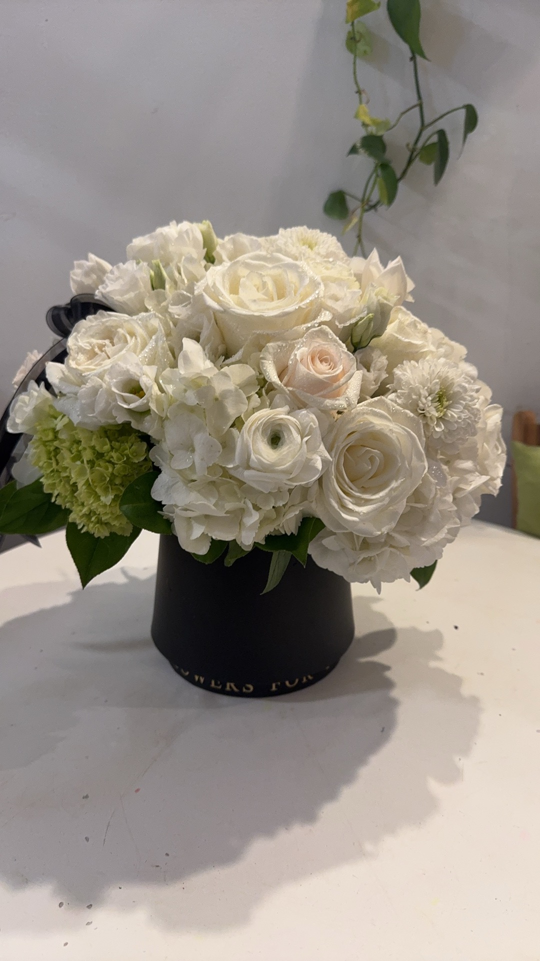 All white roses with black vase