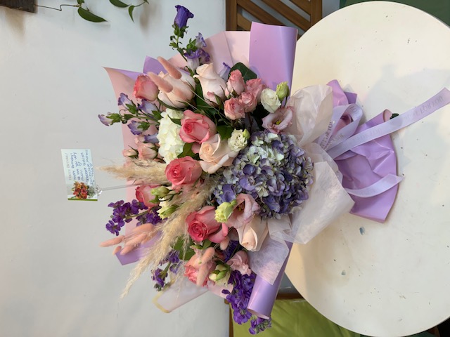 A purple bouquet with pink, purple, and white flowers